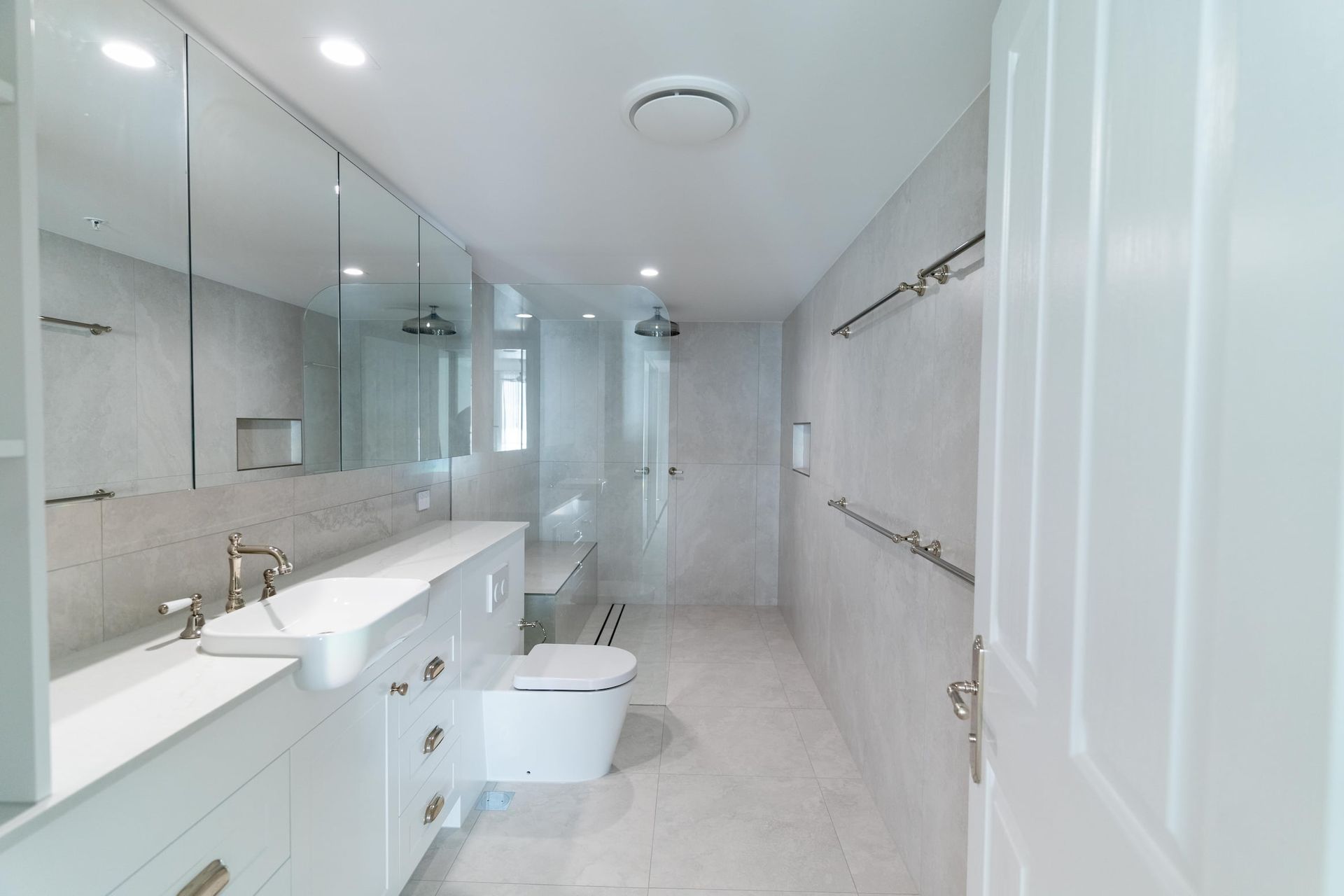 A bathroom with a toilet , sink , and mirror.