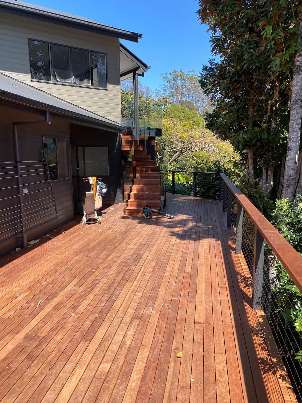 A wooden deck with stairs leading up to a house.