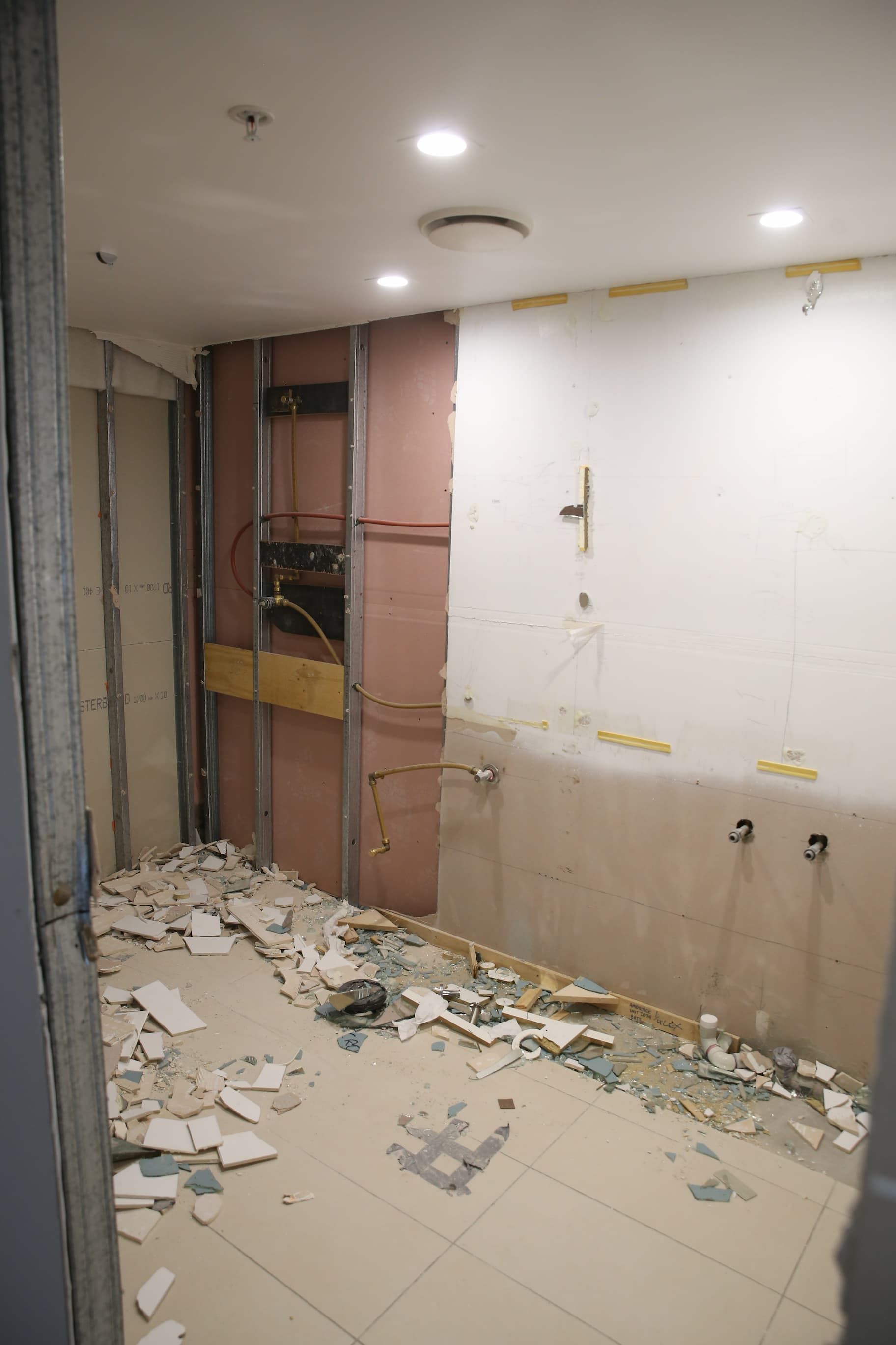 A room with a lot of broken tiles on the floor and walls.