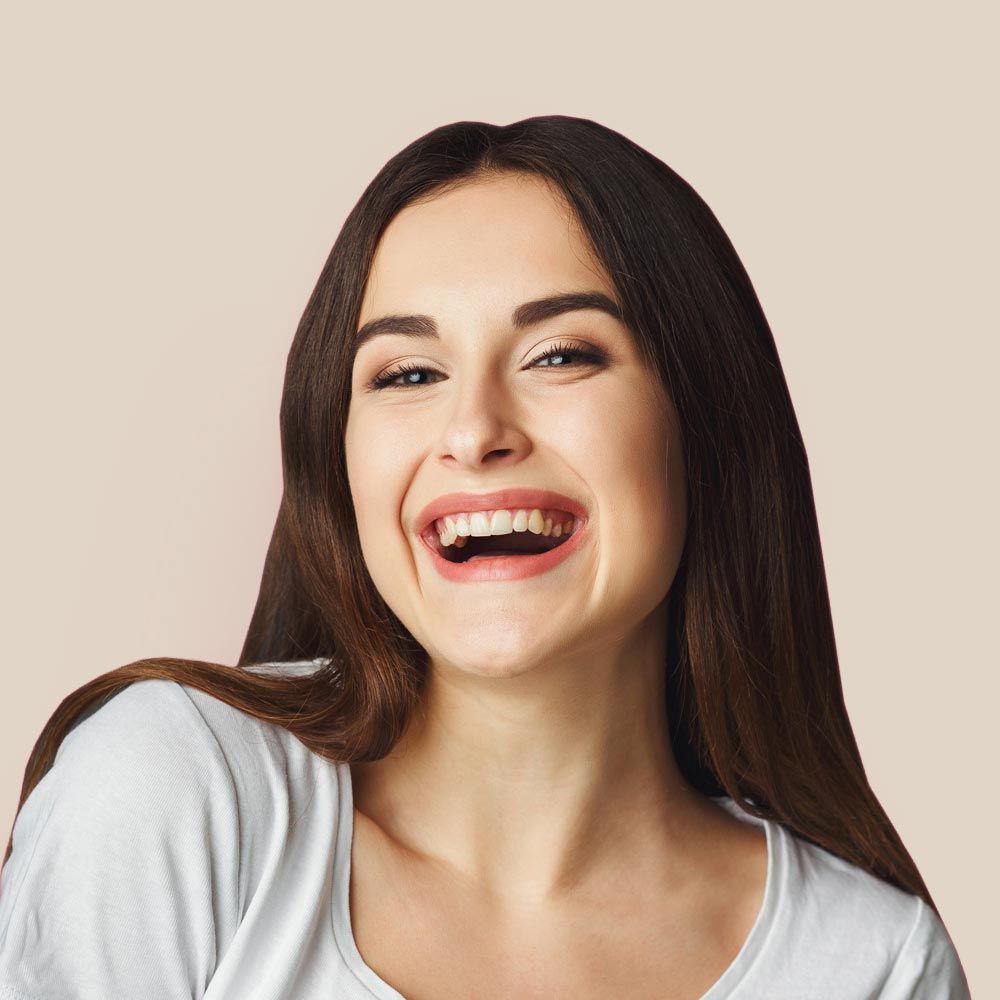 A woman is laughing with her mouth open and wearing a white shirt.