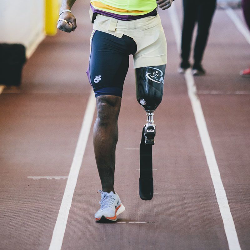 A man with a prosthetic leg is running on a track