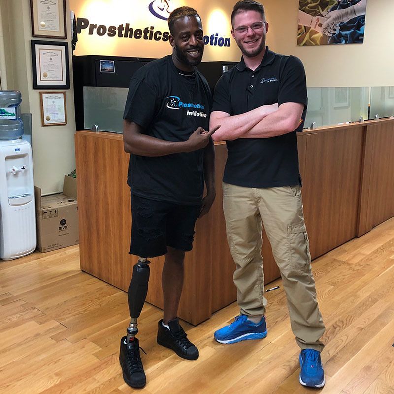 Two men standing in front of a sign that says prosthetics