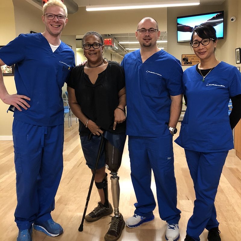 A group of people in blue scrubs pose for a picture