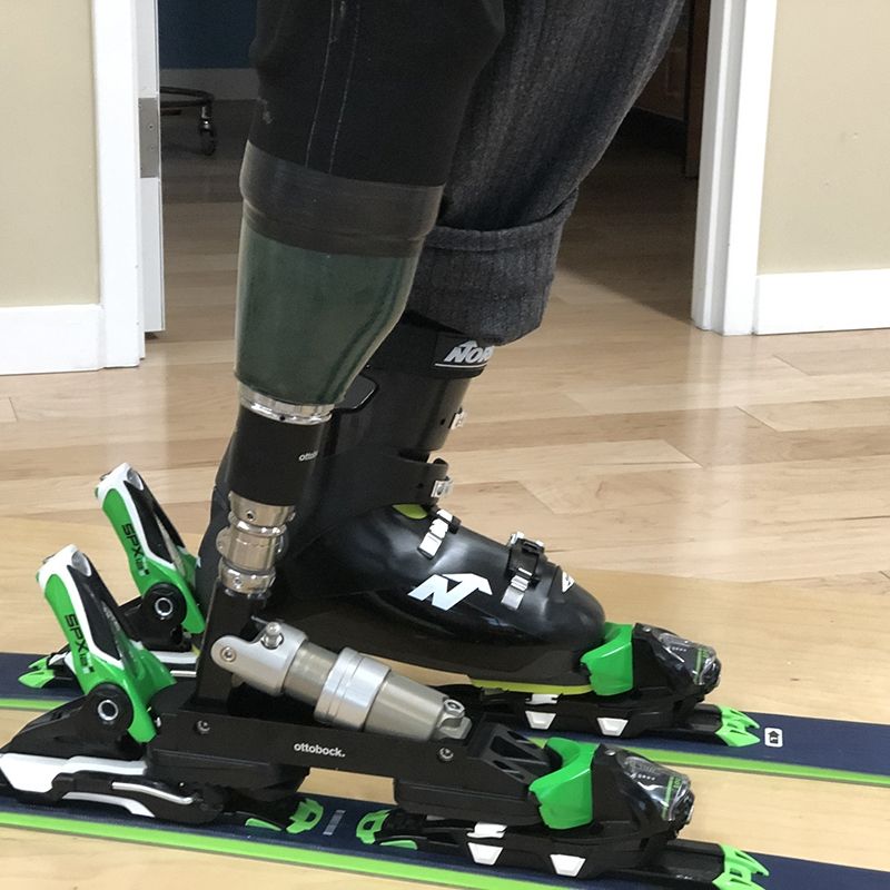A person with a prosthetic leg is skiing