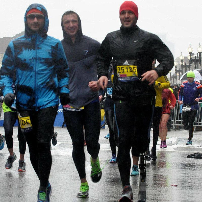 A group of runners are running in the rain and one of them has a tag that says 25125