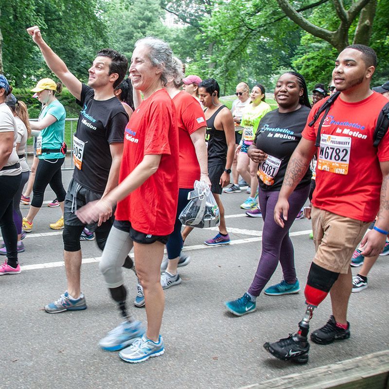 A group of amputees from prosthetics in motion are walking down the street at the achilles hope and possibility race