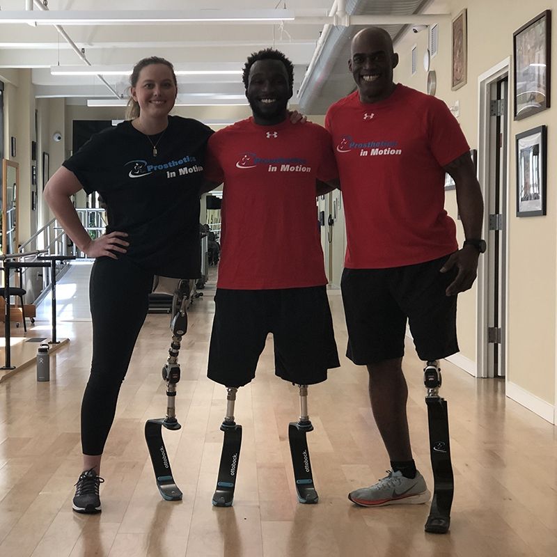 Three people with prosthetic legs are posing for a picture