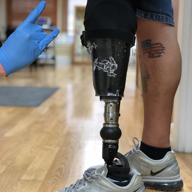 A person with a tattoo on their leg is wearing a prosthetic leg