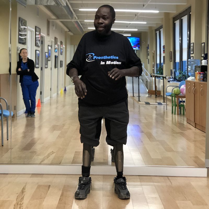 A man wearing a black shirt that says prosthetics in motion