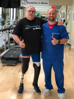 A man with a prosthetic leg is standing next to a nurse