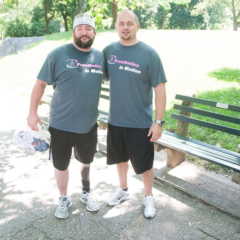 Two men standing next to each other wearing shirts that say prosthetics in medicine