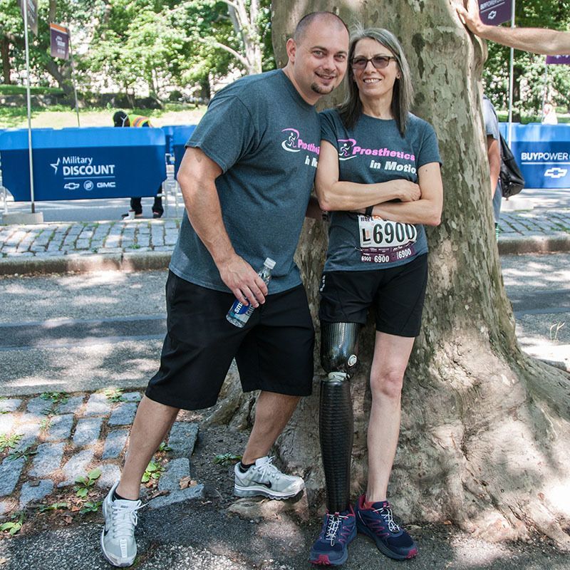 Chris Kort and a woman standing next to a tree with the woman having a prosthetic leg