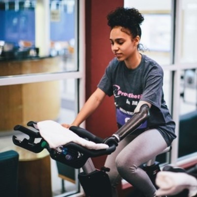 A woman with a prosthetic arm is riding a bike