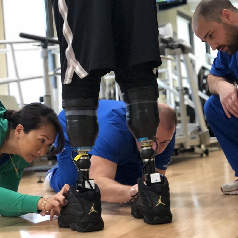 A man with a prosthetic leg is being examined by two people