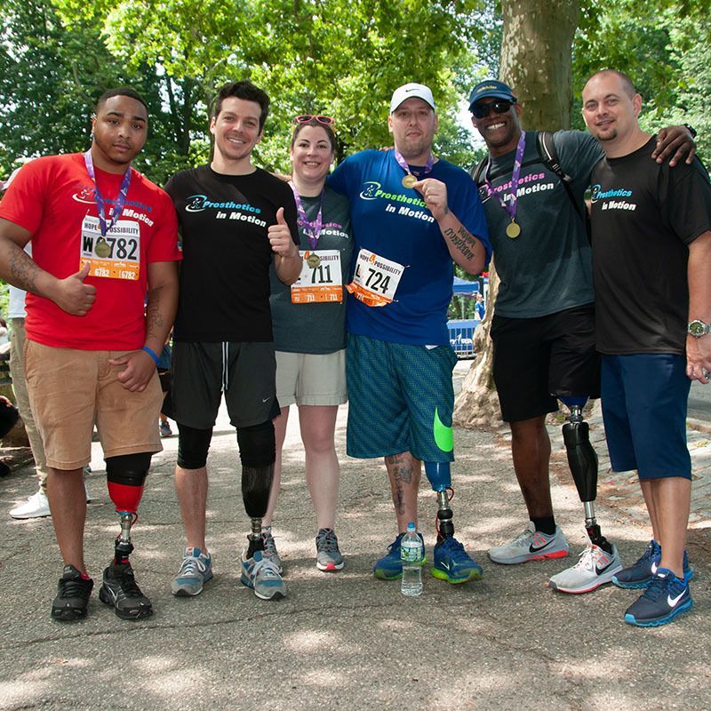 A group of people with prosthetic legs are posing for a picture