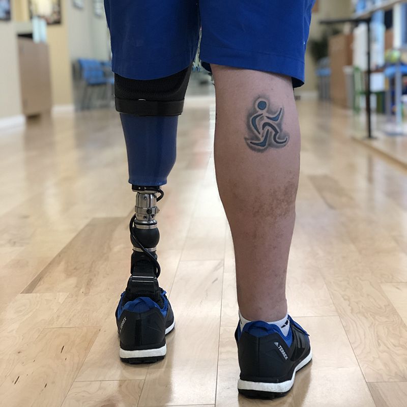 A person with a prosthetic leg has a tattoo on their leg