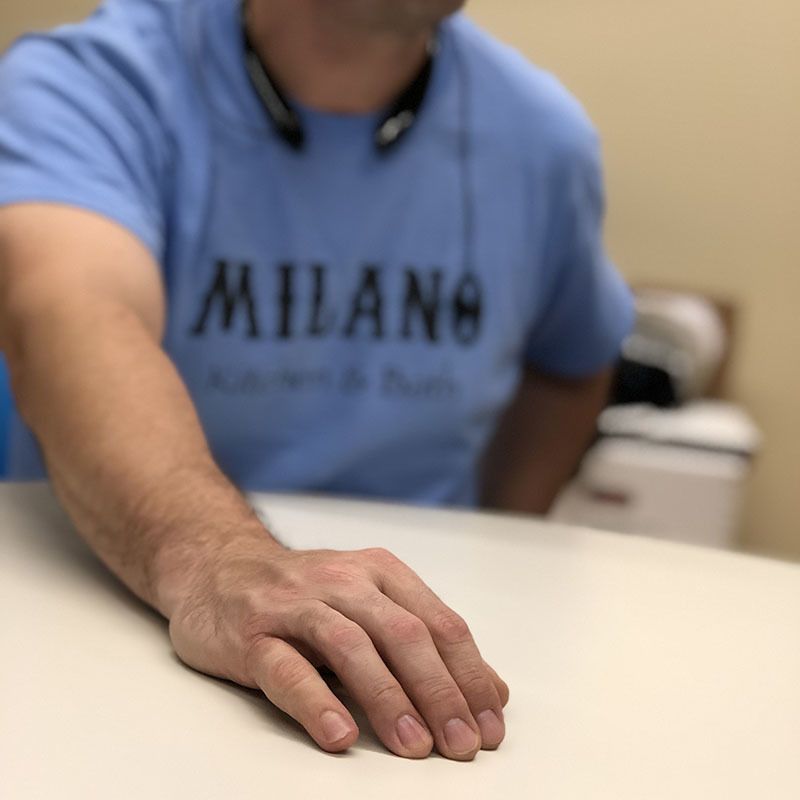 A man wearing a blue shirt that says milano on it