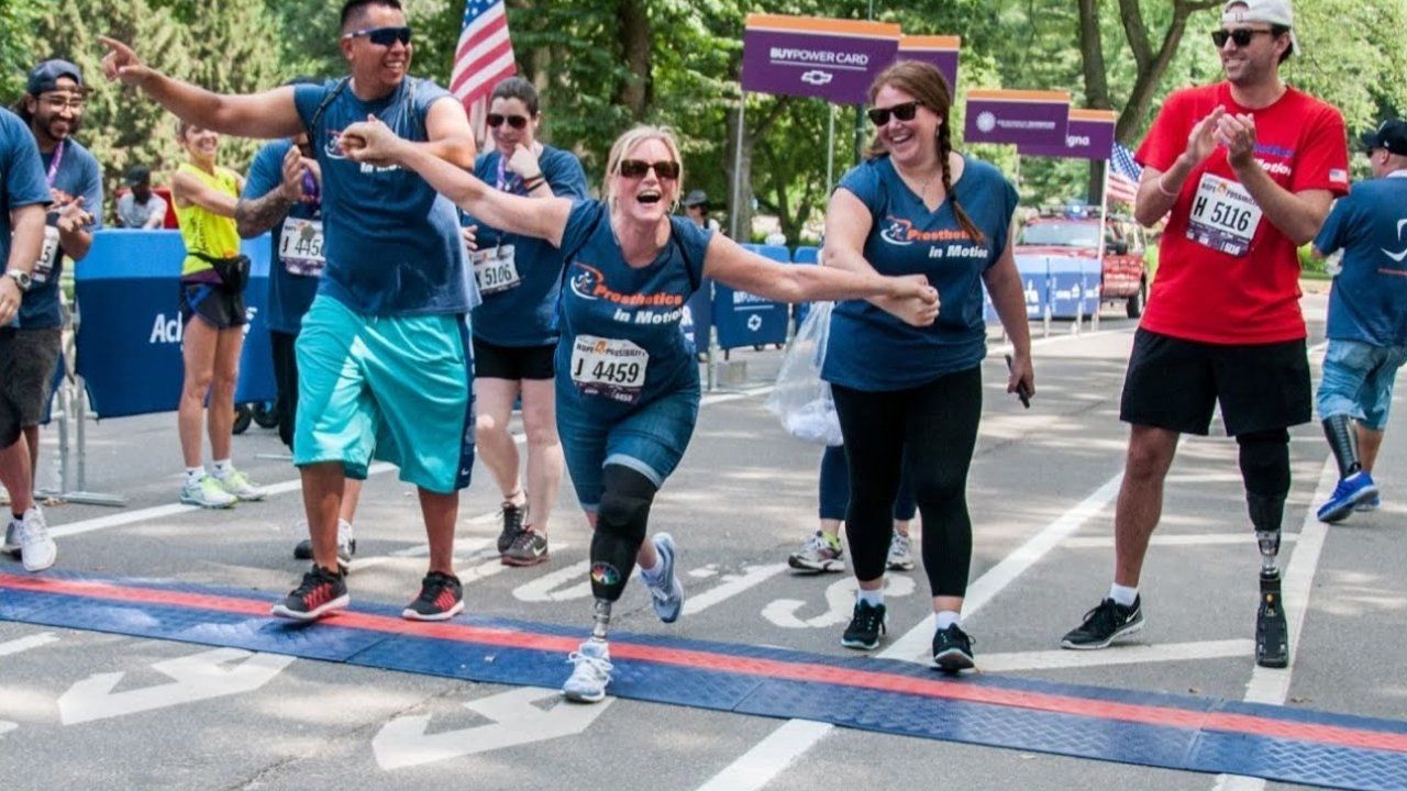 A group of people are running a race and one of them has a prosthetic leg