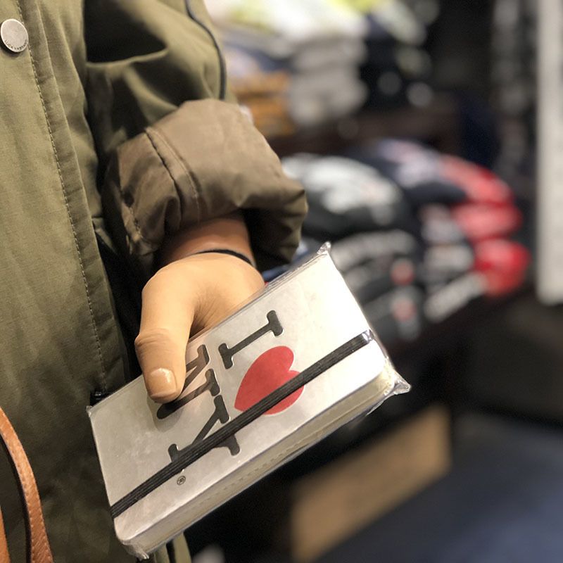 A person is holding a notebook that says i love ny