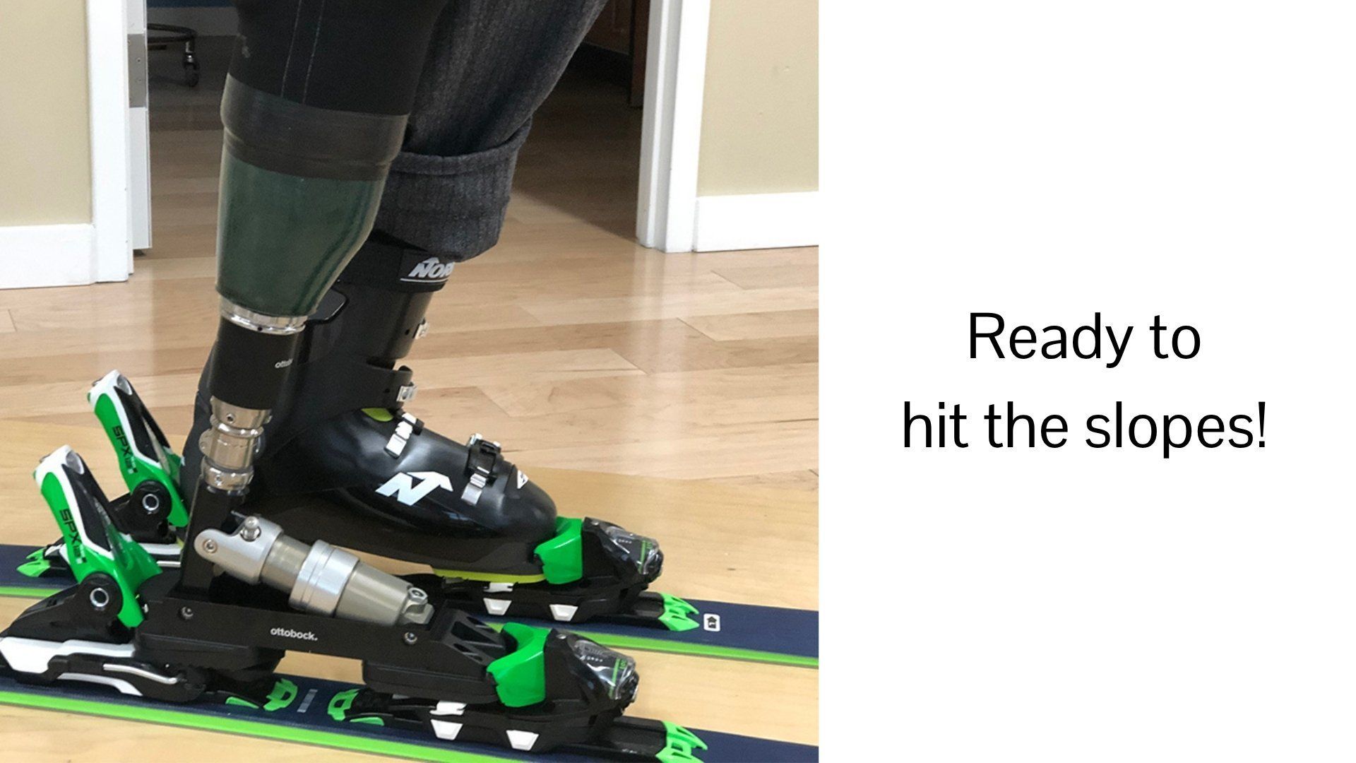 A person with a prosthetic leg is skiing down a wooden floor.
