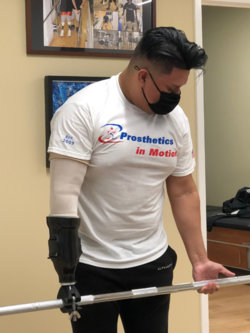 A man wearing a white shirt that says prosthetics in motion