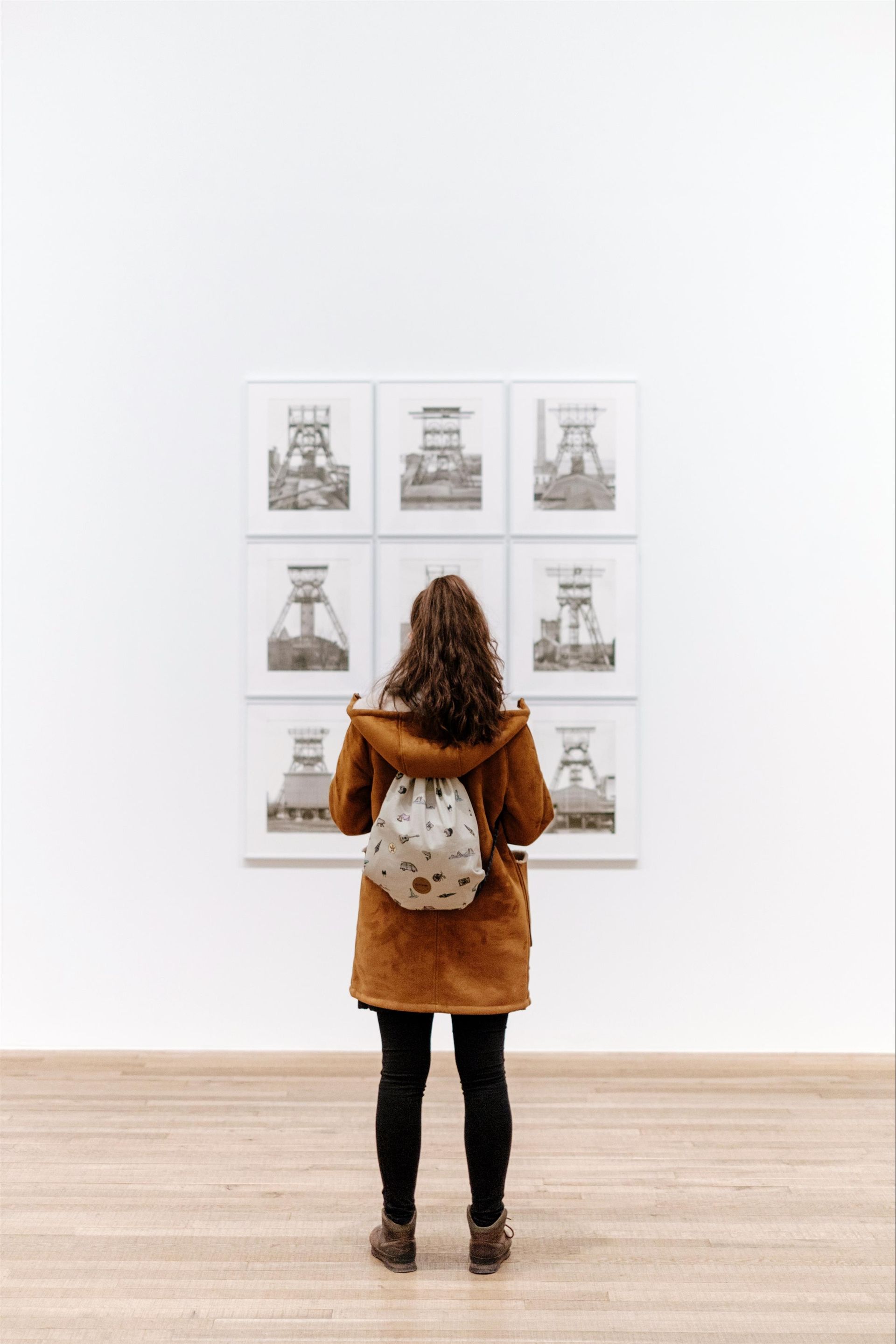 A woman is looking at a painting in a museum.