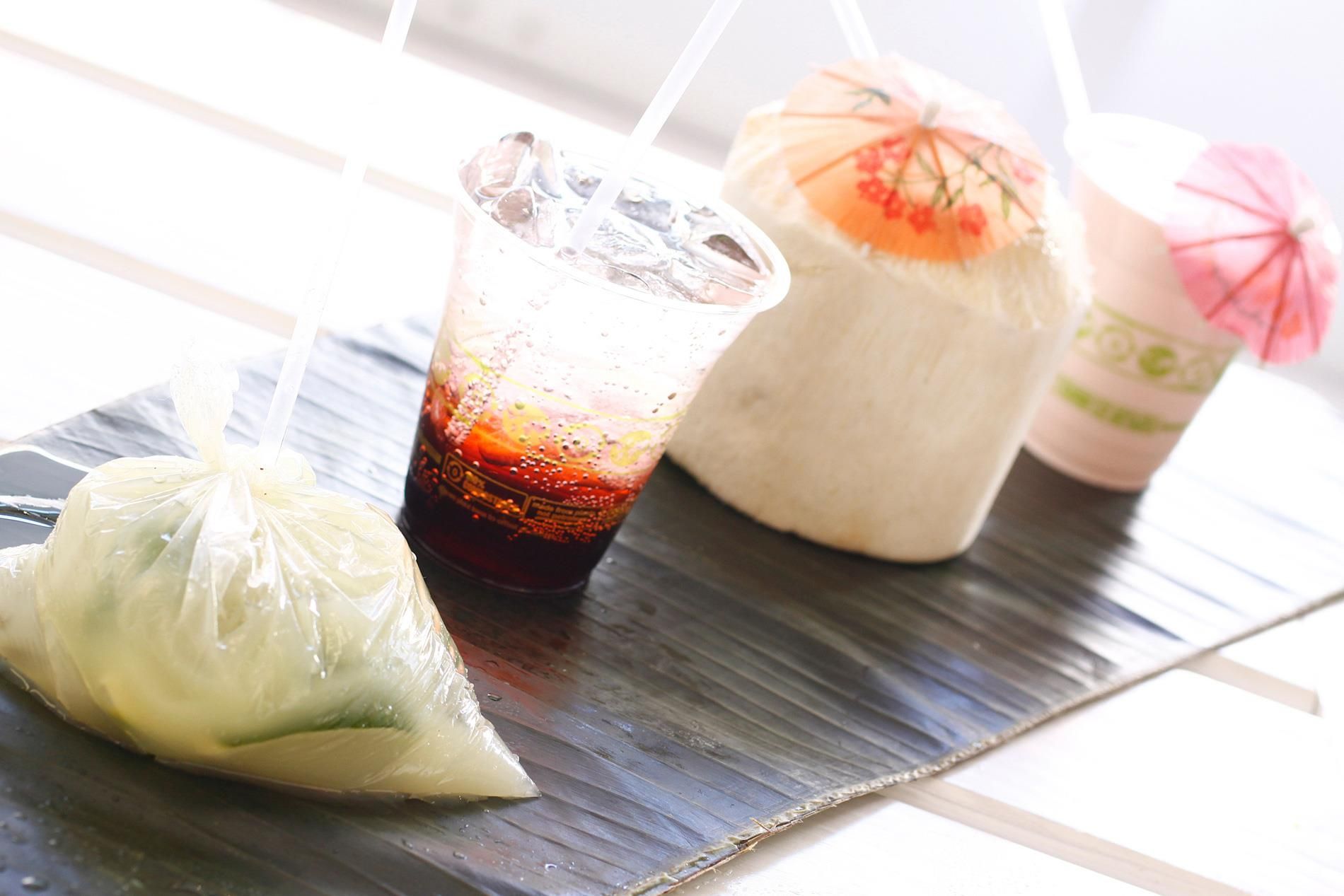 Three drinks and a bag of food are on a table.