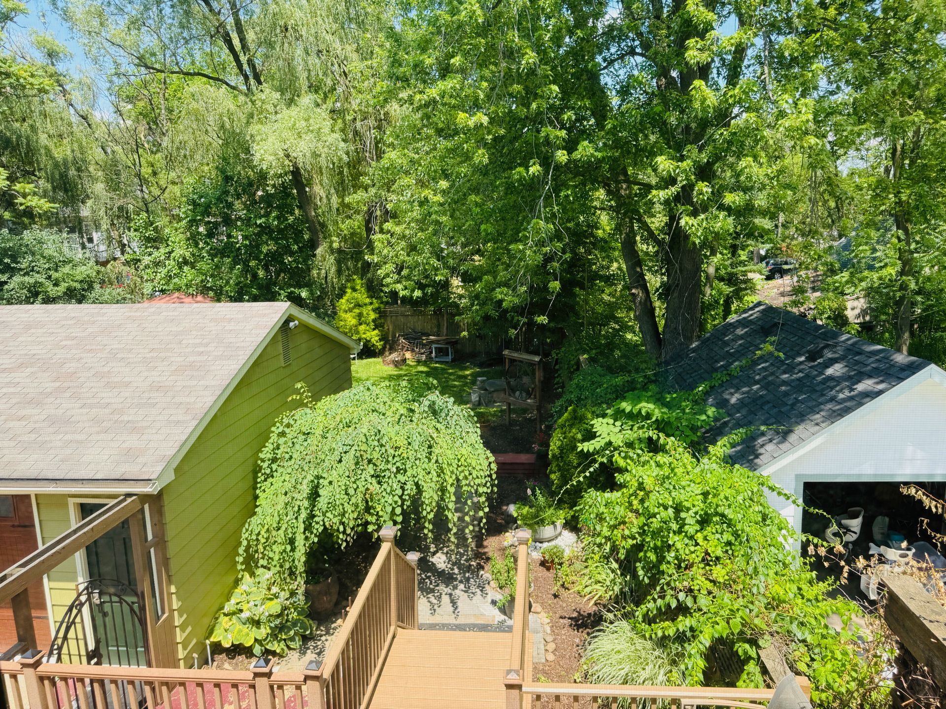 An aerial view of a house with a deck and trees in the background.