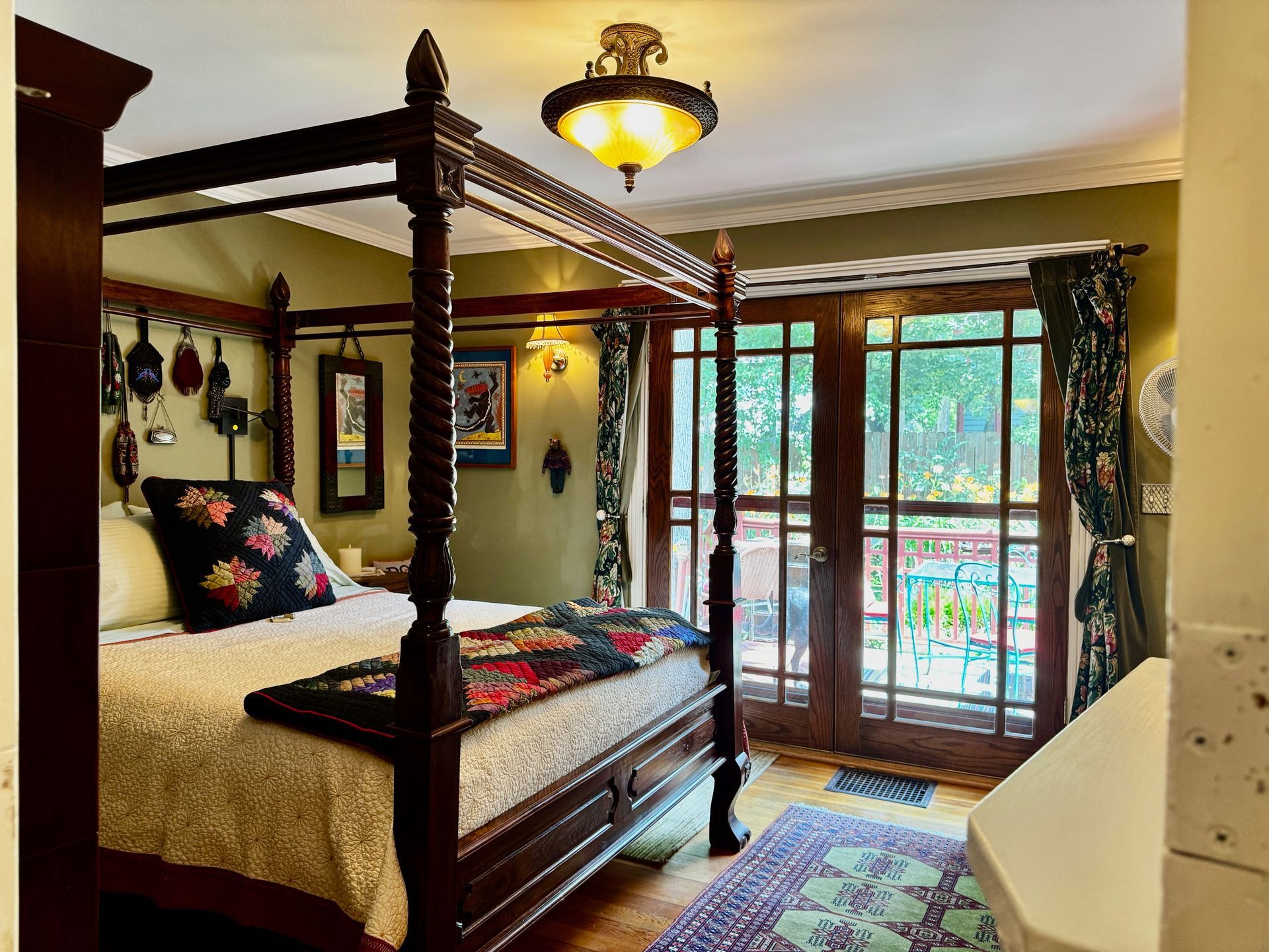 A bedroom with a four poster bed and sliding glass doors.