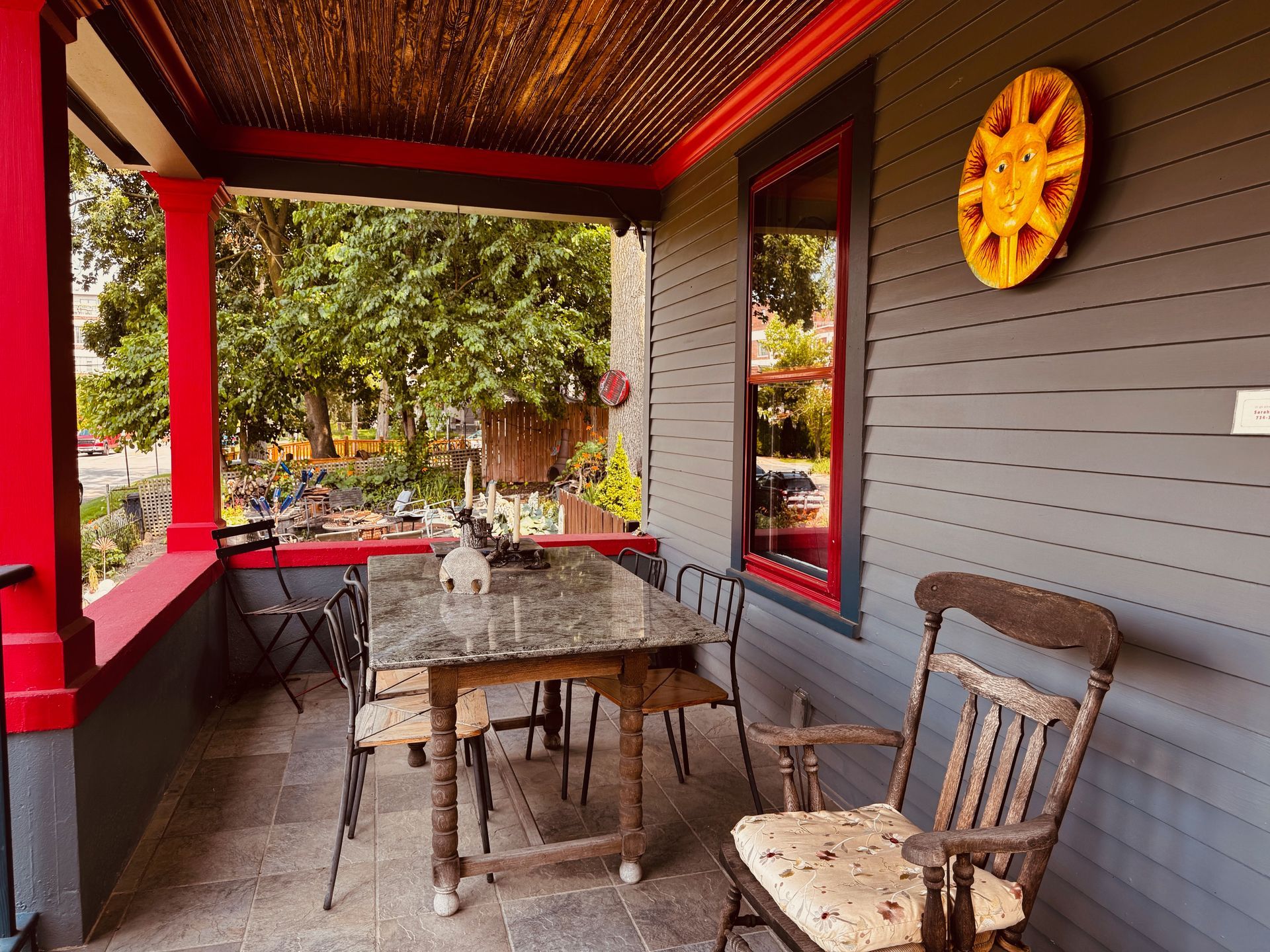 A porch with a table and chairs and a wheel on the wall