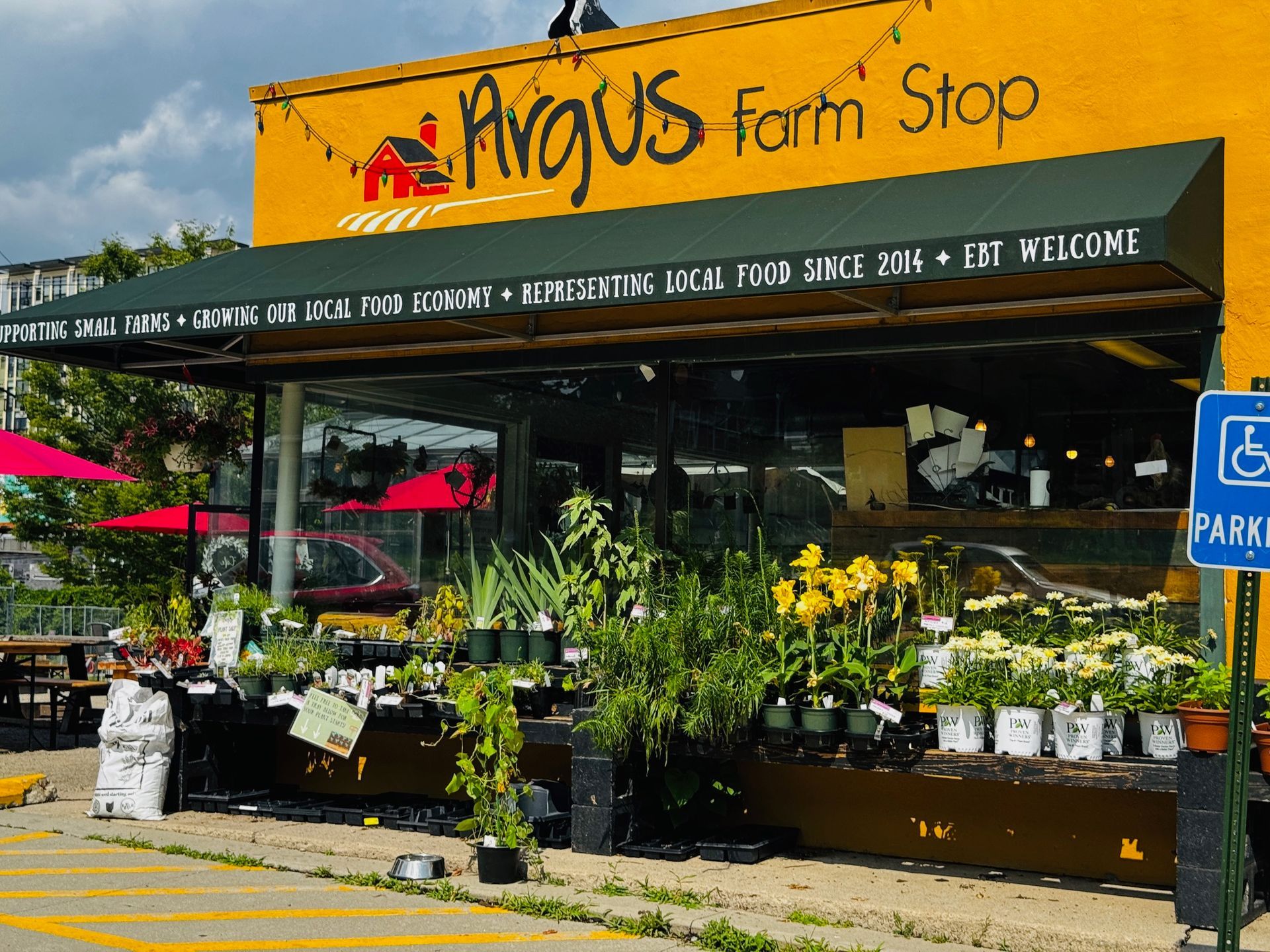 A yellow building with a green awning that says avacus farm stop