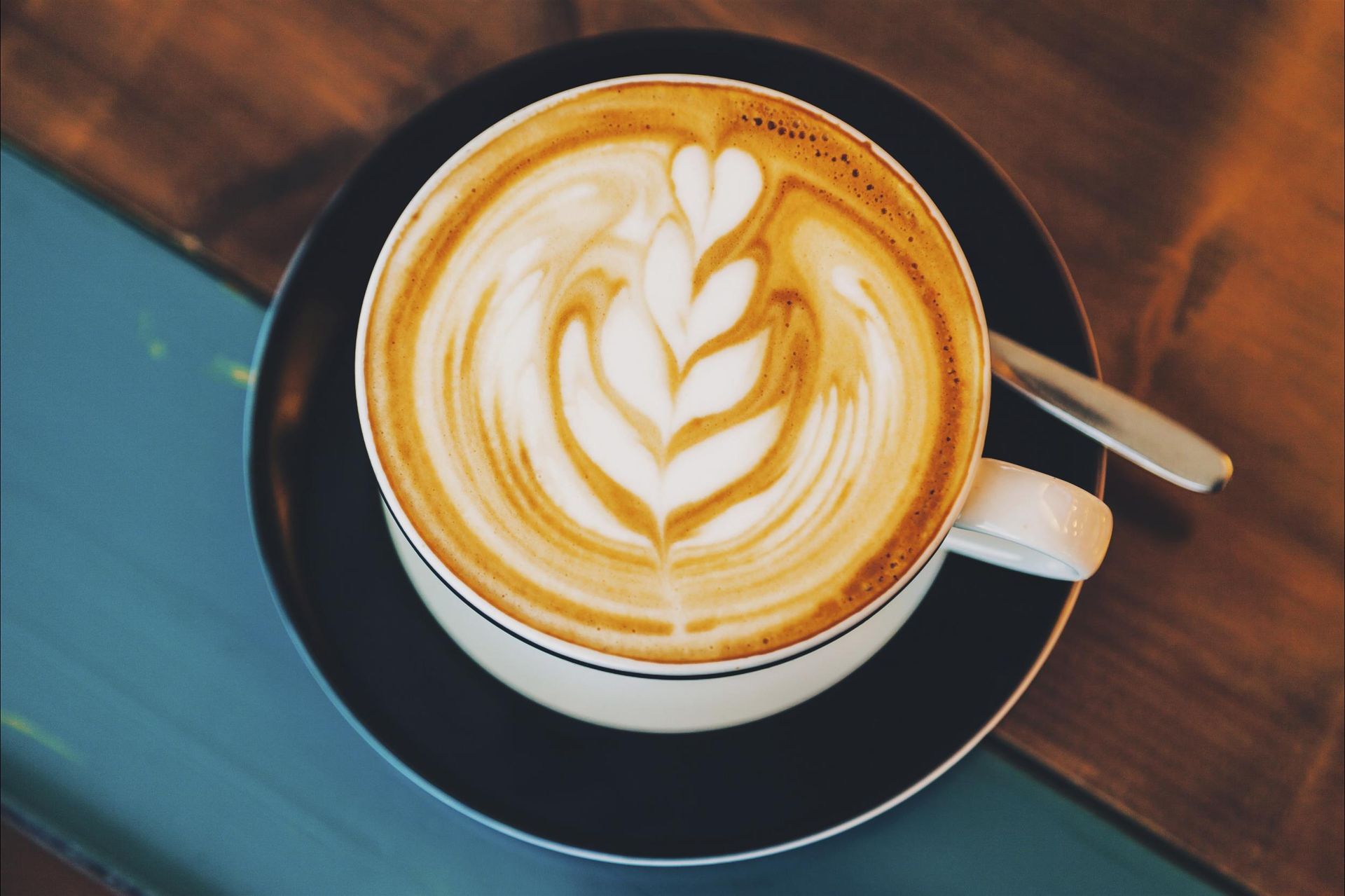 A cup of cappuccino with a leaf design on the milk