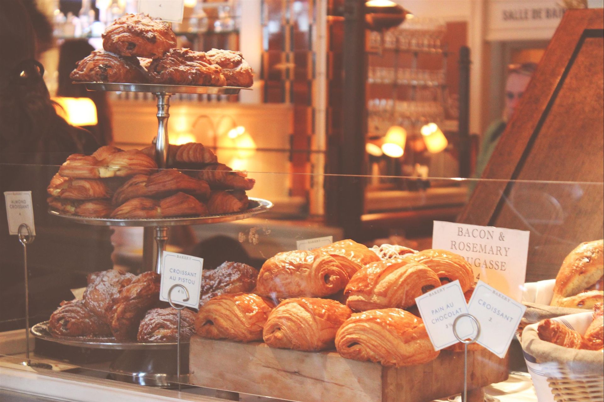 A variety of pastries are displayed in a bakery window.
