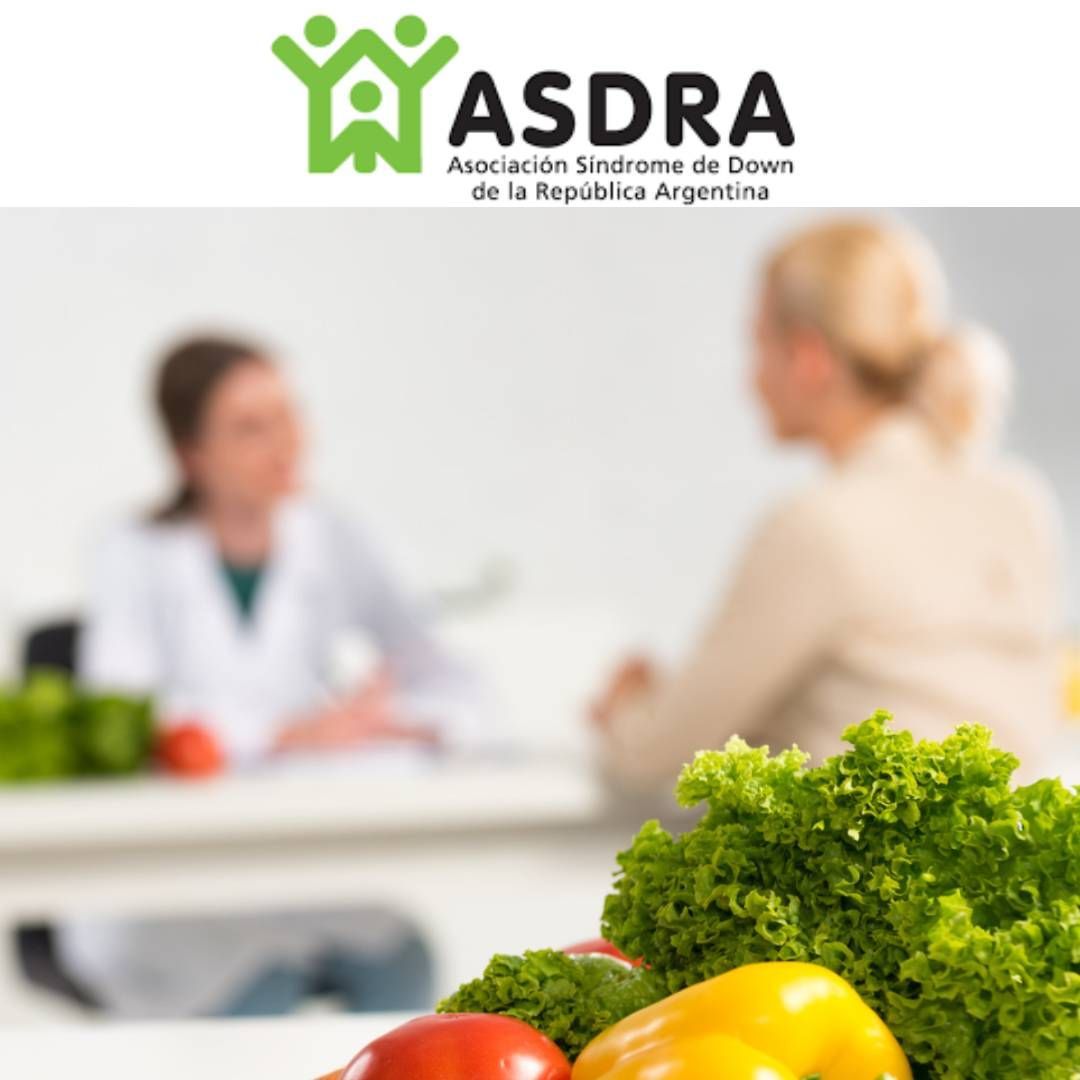 Logotipo de ASDRA sobre una escena borrosa de una consulta con un médico y una exhibición de verduras frescas.