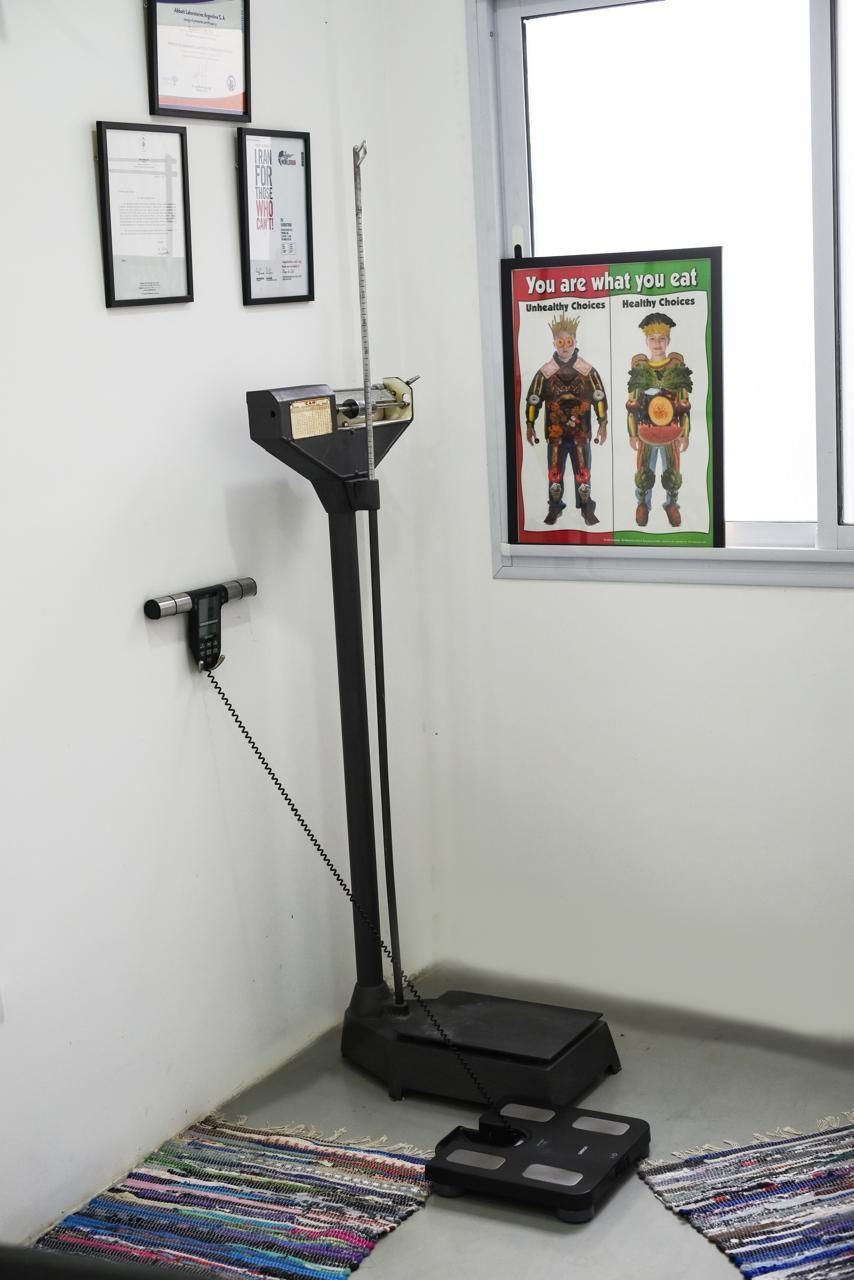 Esfera de báscula de peso que apunta a 70 kg, con una cara blanca y marcas negras sobre un fondo de madera.