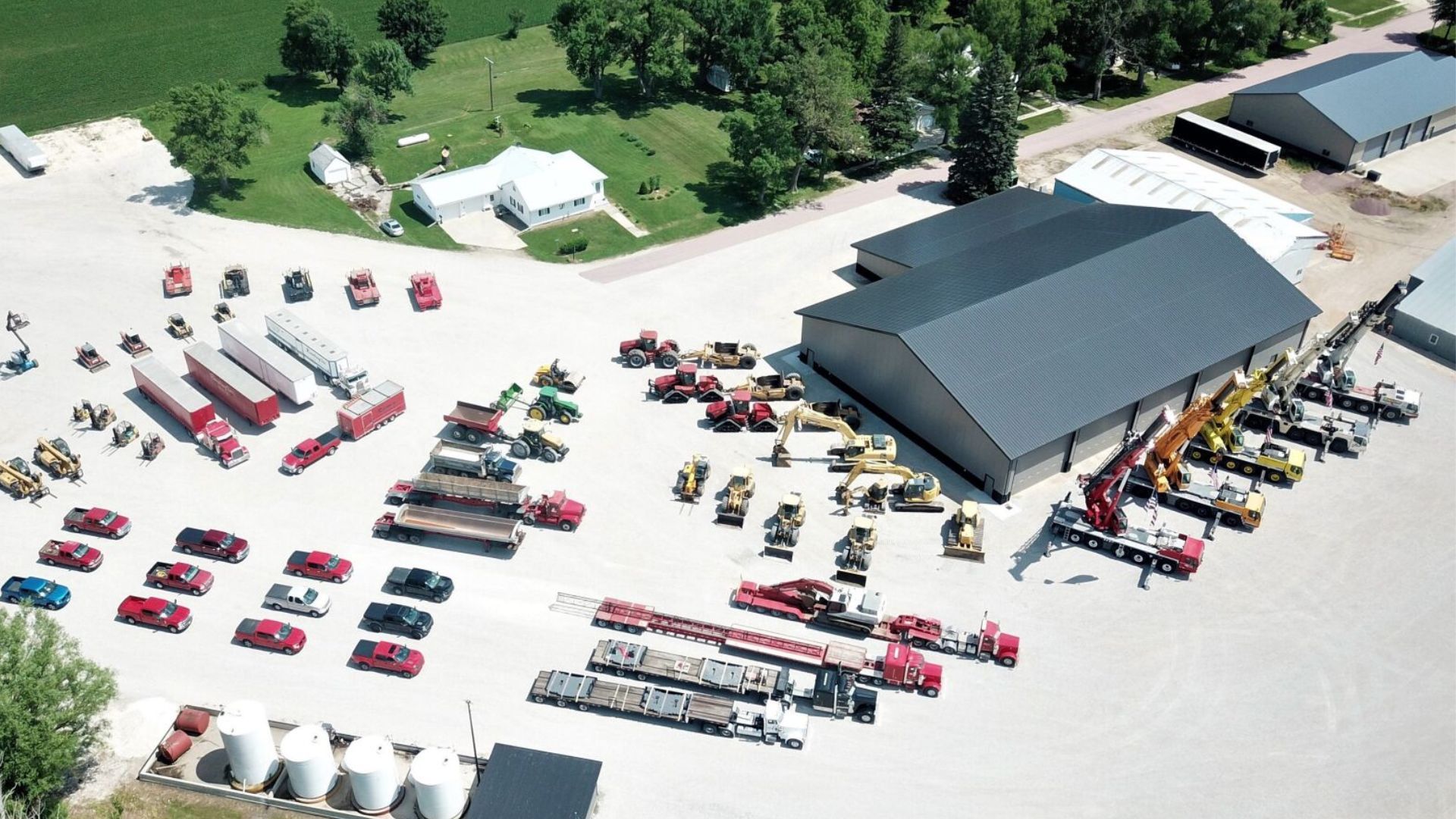 An aerial view of a warehouse with a lot of trucks parked in front of it