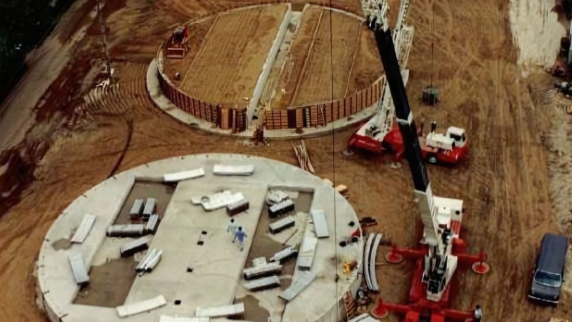 An aerial view of a construction site with a crane in the foreground