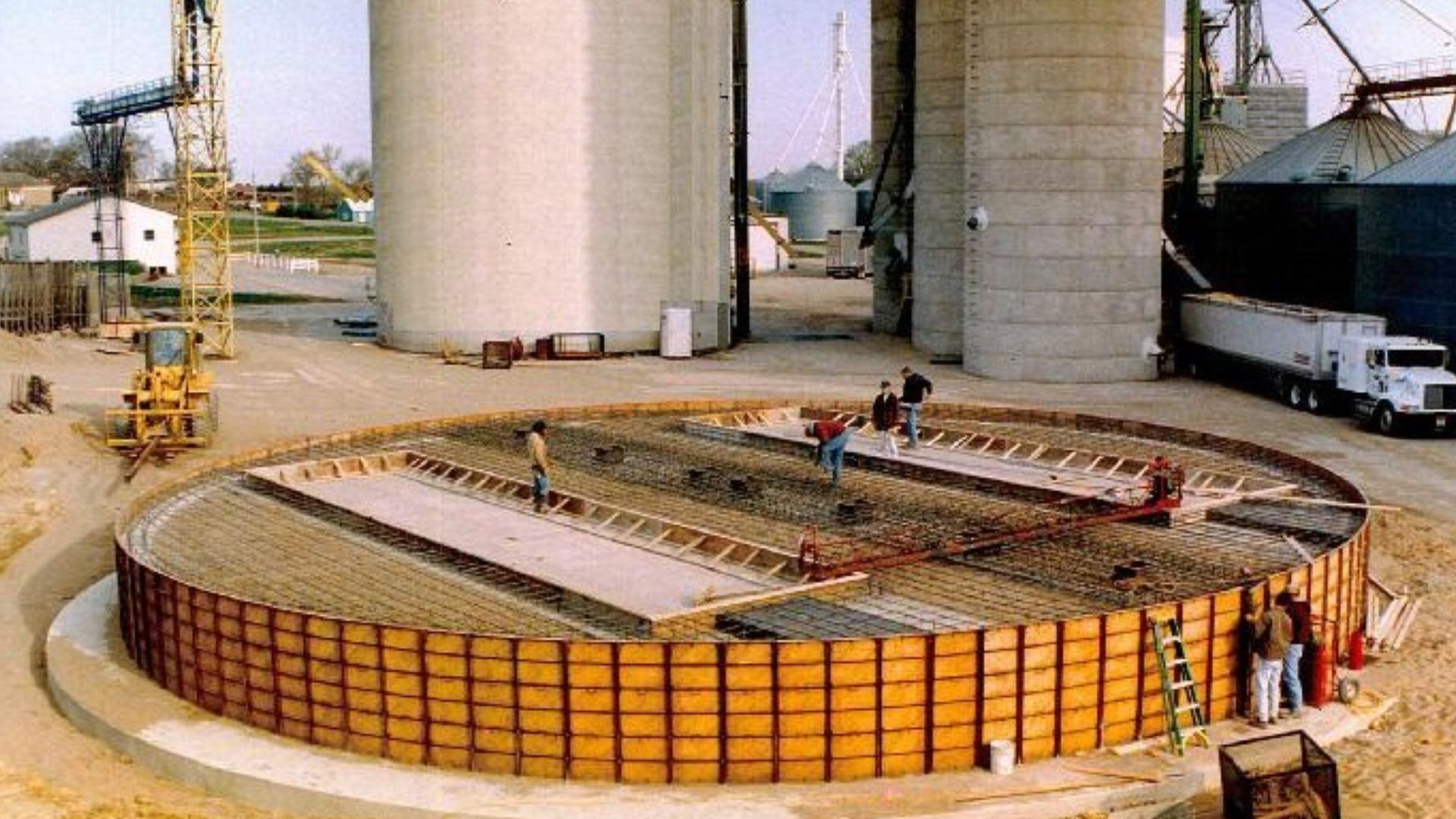 A group of people are standing around a large circular structure