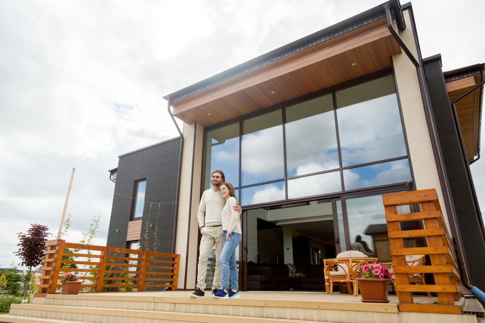 A Man and a Woman Are Standing in Front of a Large House — Loan Select Tablelands in Atherton, QLD
