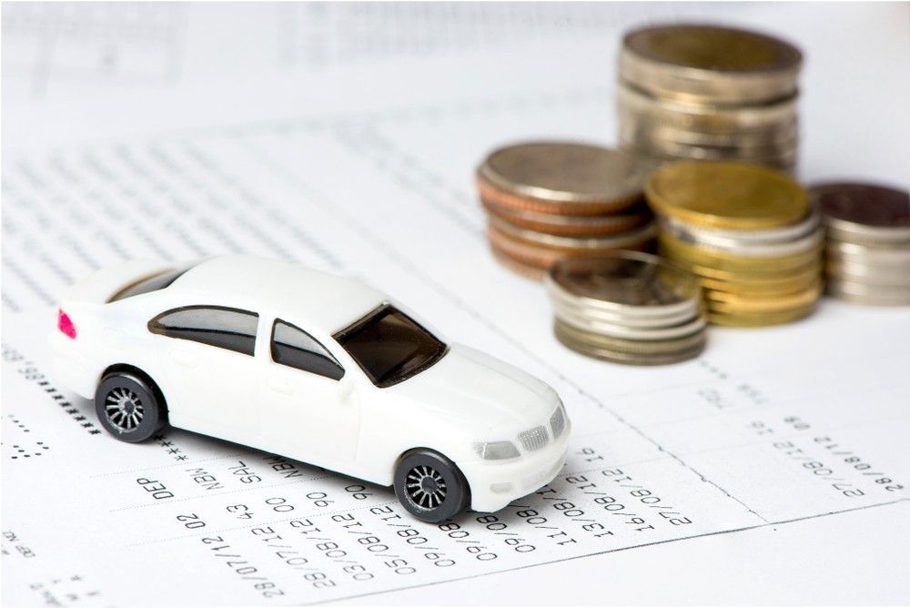 A Toy Car is Sitting on Top of a Calendar Next to Stacks of Coins — Loan Select Tablelands in Atherton, QLD