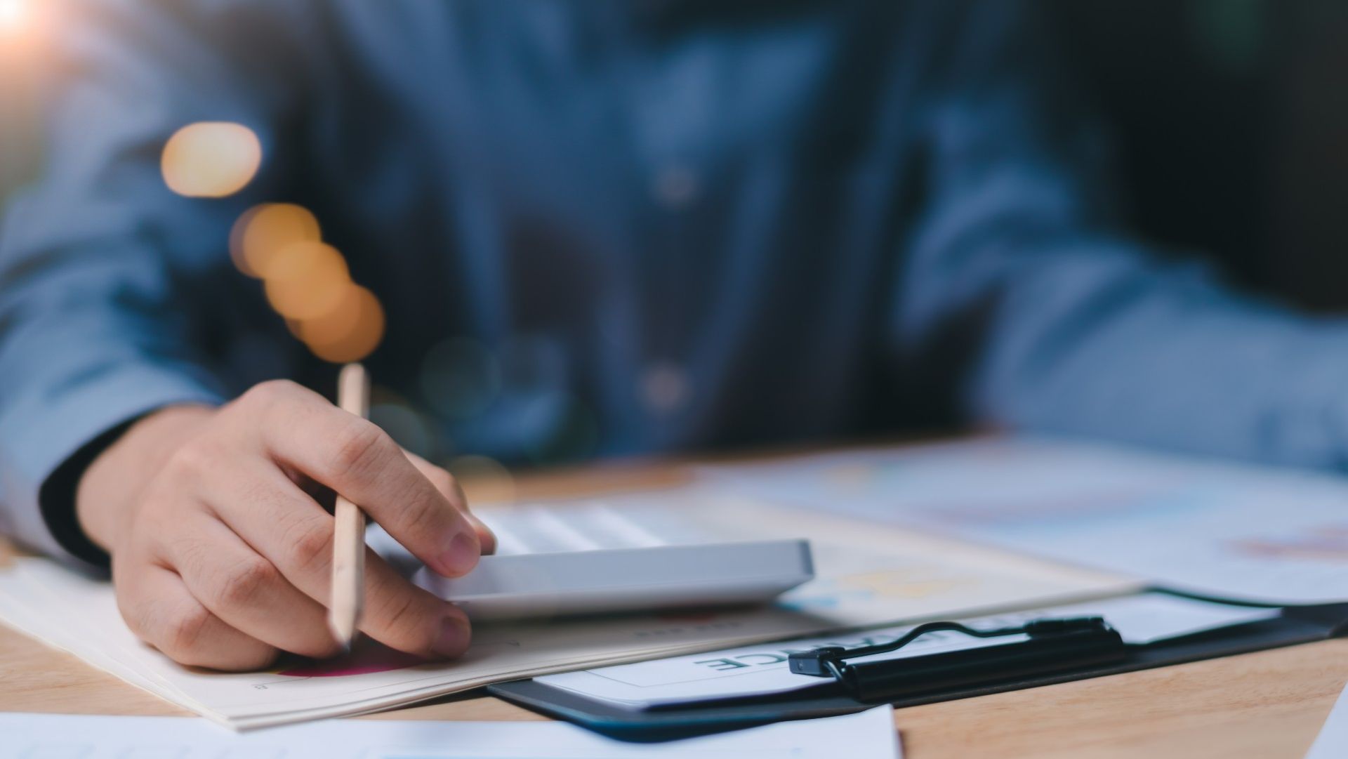 A Person is Writing on a Piece of Paper While Using a Calculator — Loan Select Tablelands in Atherton, QLD