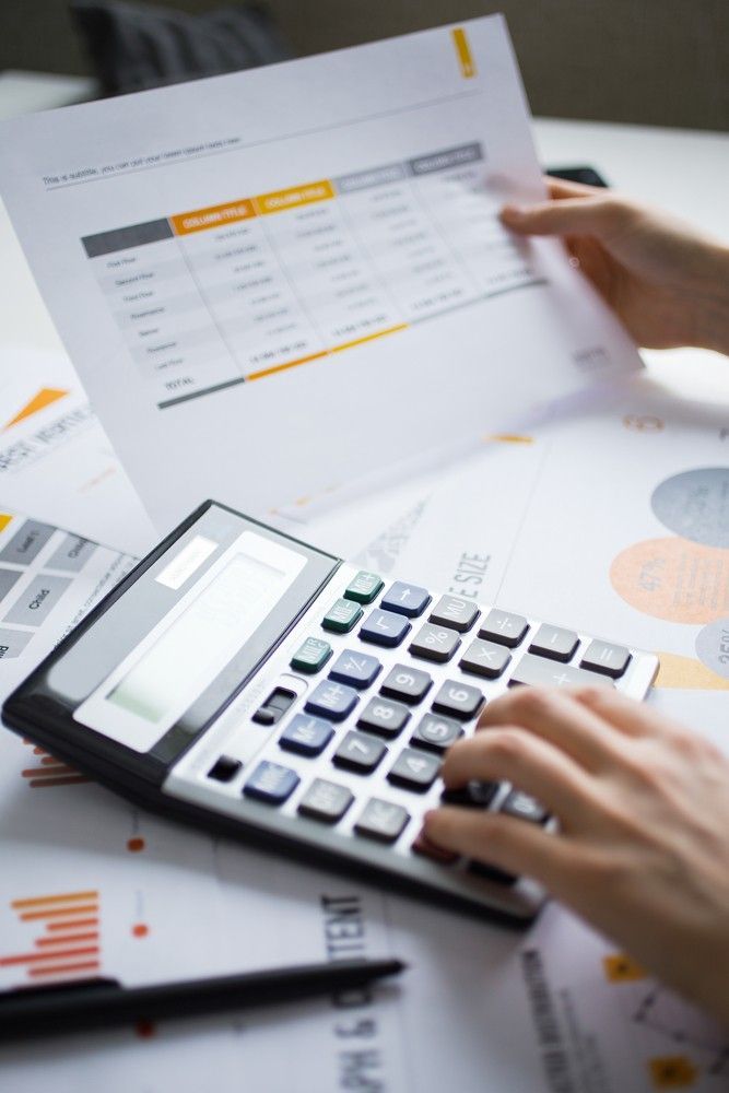 A Person is Typing on a Calculator While Holding a Piece of Paper — Loan Select Tablelands in Atherton, QLD