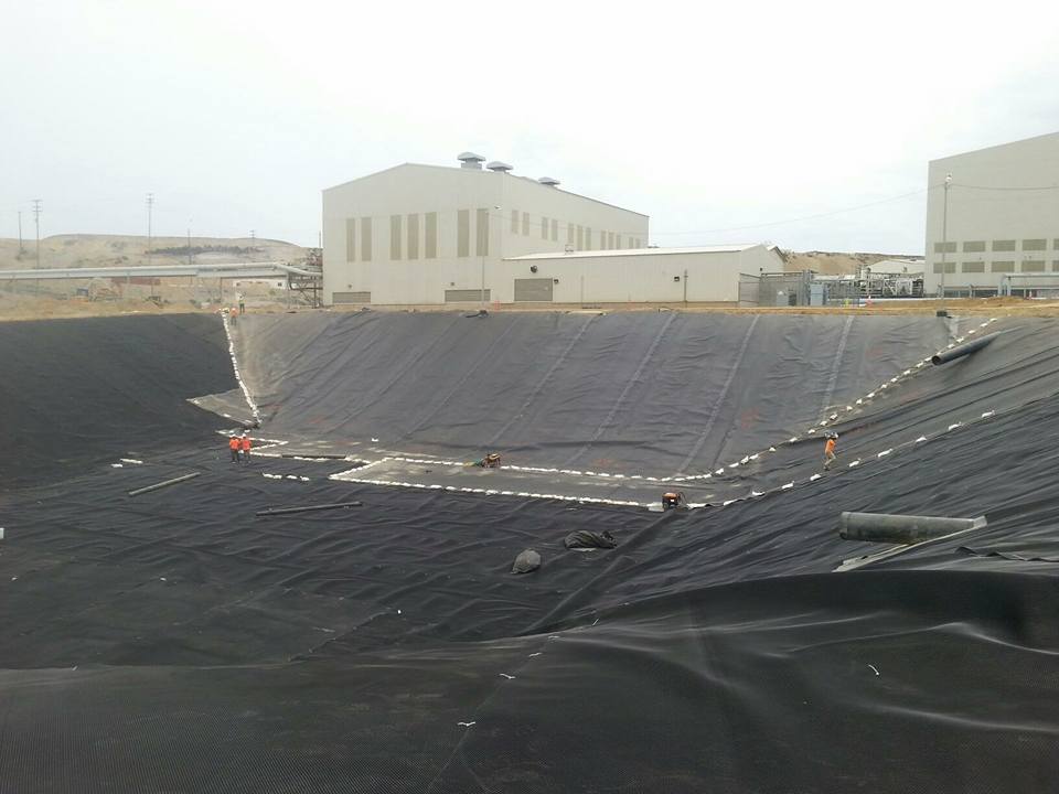 Resevoir-sized area lined with black liner.  Building on the side