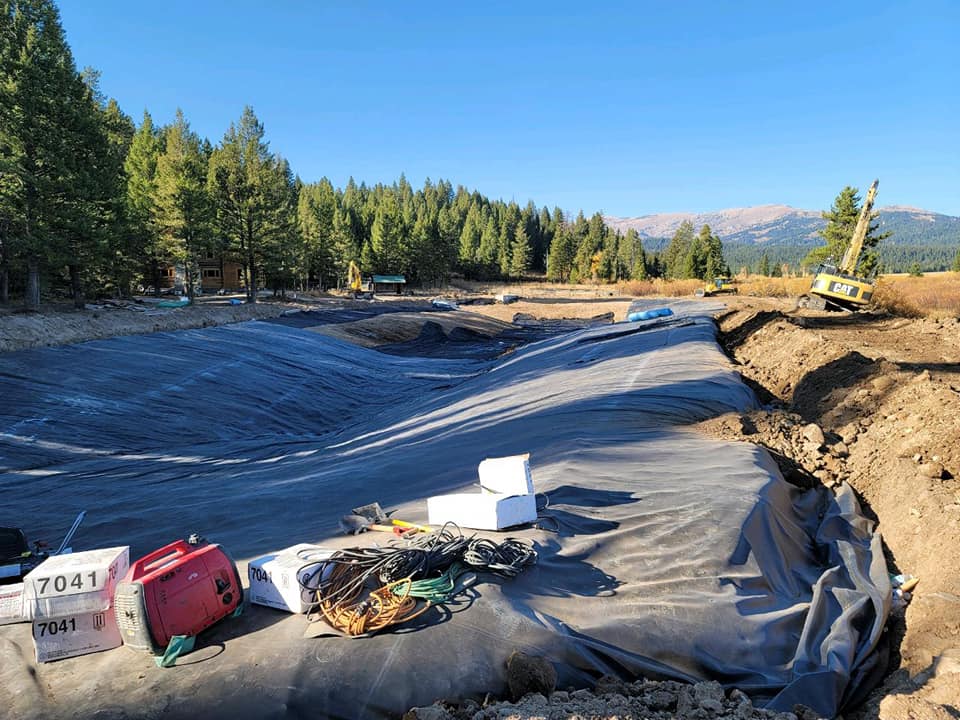 Area surrounded by pine trees with liner in the process of installation
