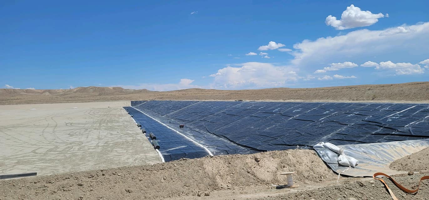 desert area with black liner stretching across the edge of an empty lake