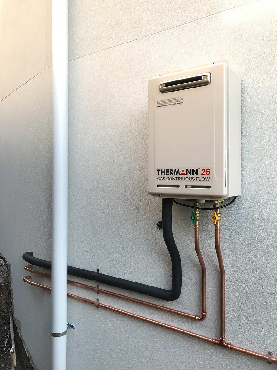A Water Heater Is Attached To A Wall With Copper Pipes — Lakesway Plumbing and Gas in Forster, NSW