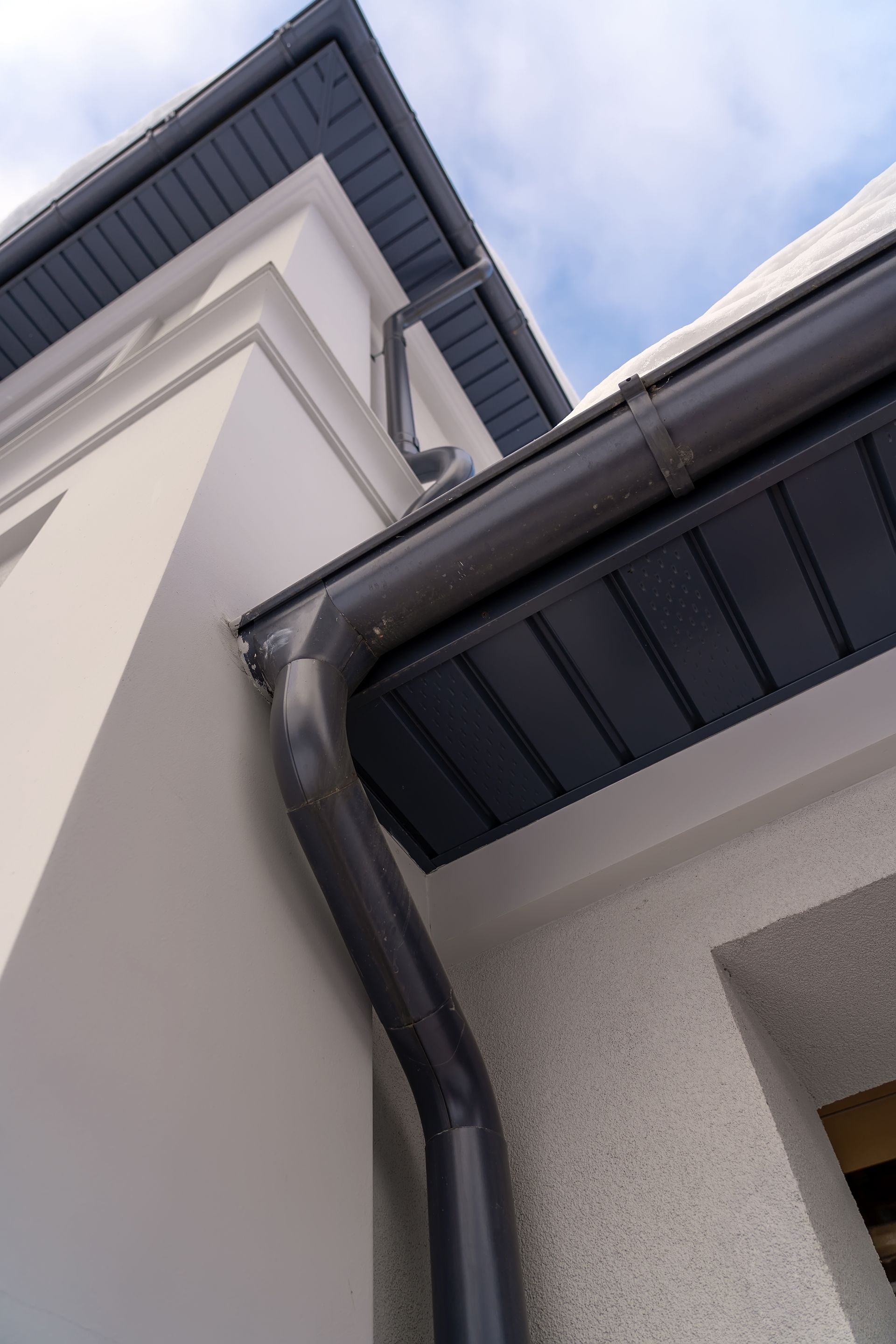 A close up of a gutter on the side of a building