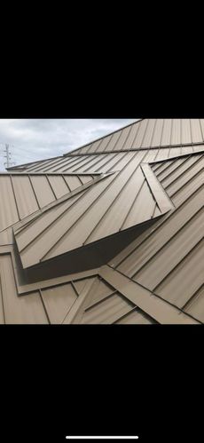 A close up of a metal roof with a skylight on it.