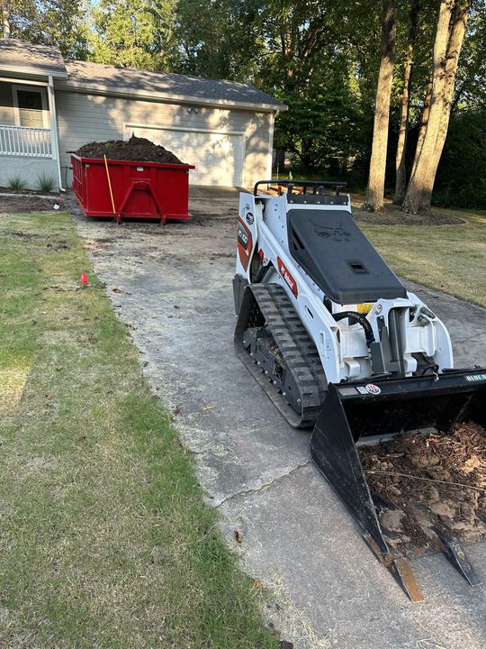 A small bulldozer is parked in front of a house.