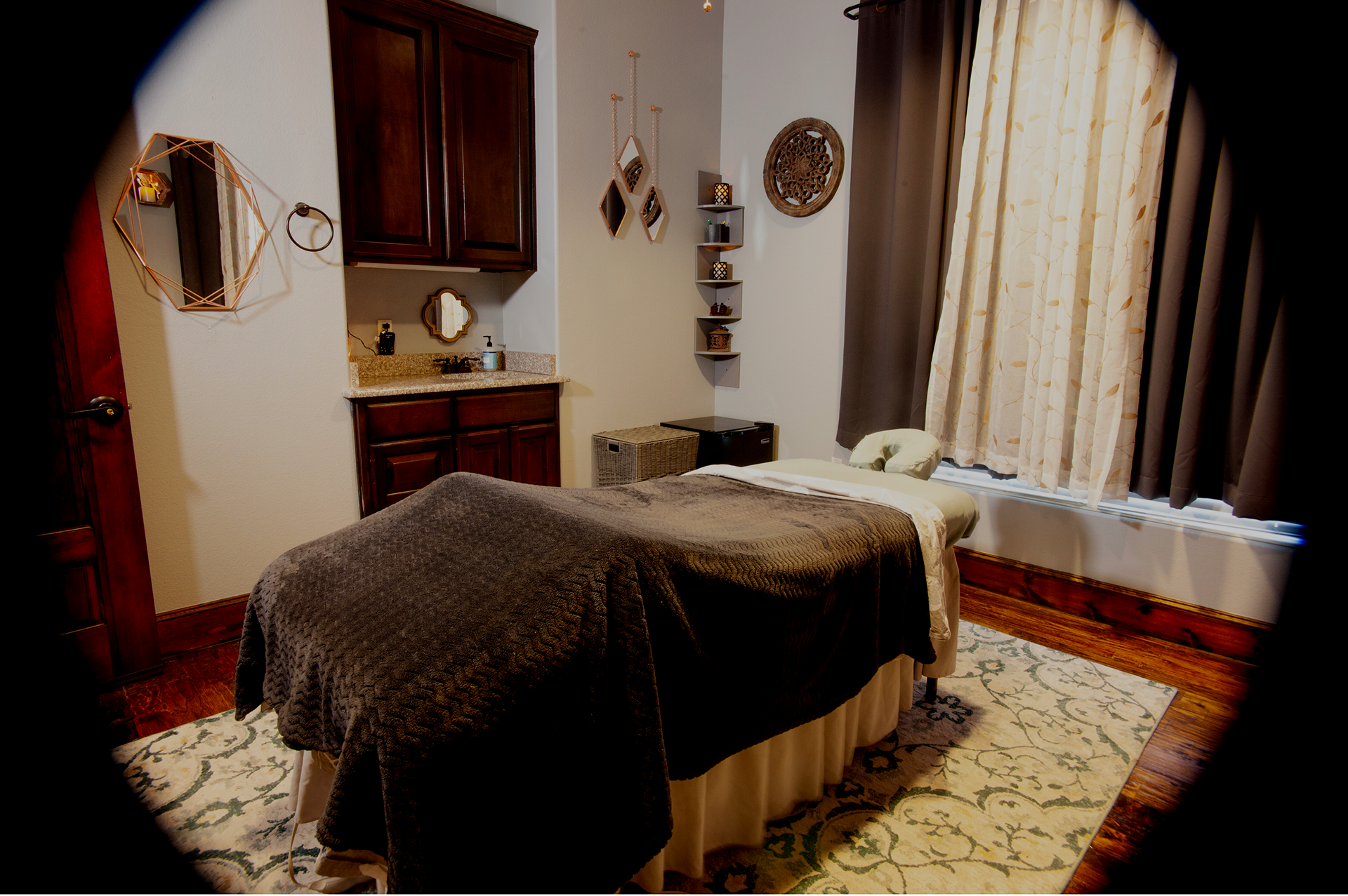 A massage table is sitting in a room next to a window.